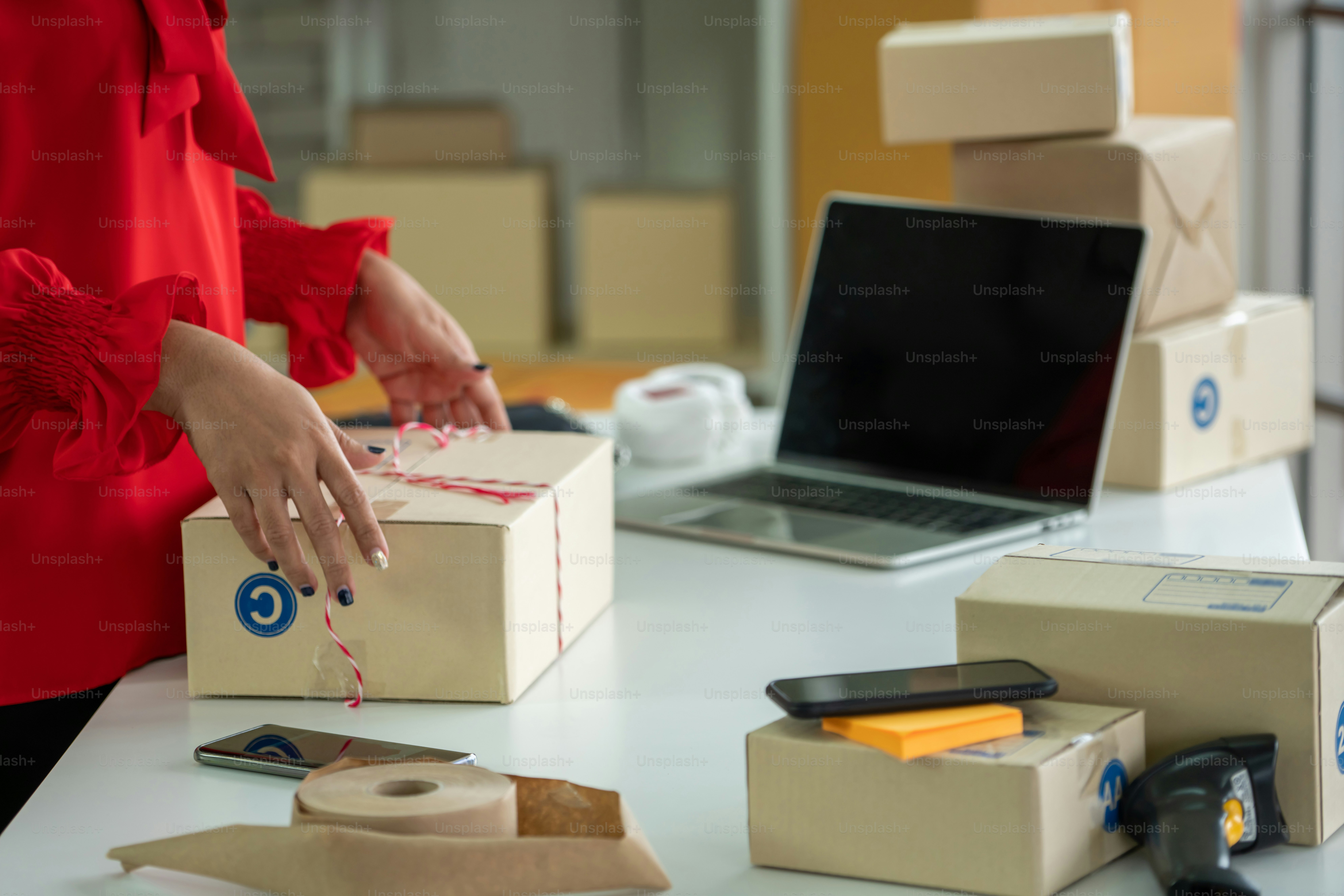 Online seller works at home office and packs shipping delivery box to ...