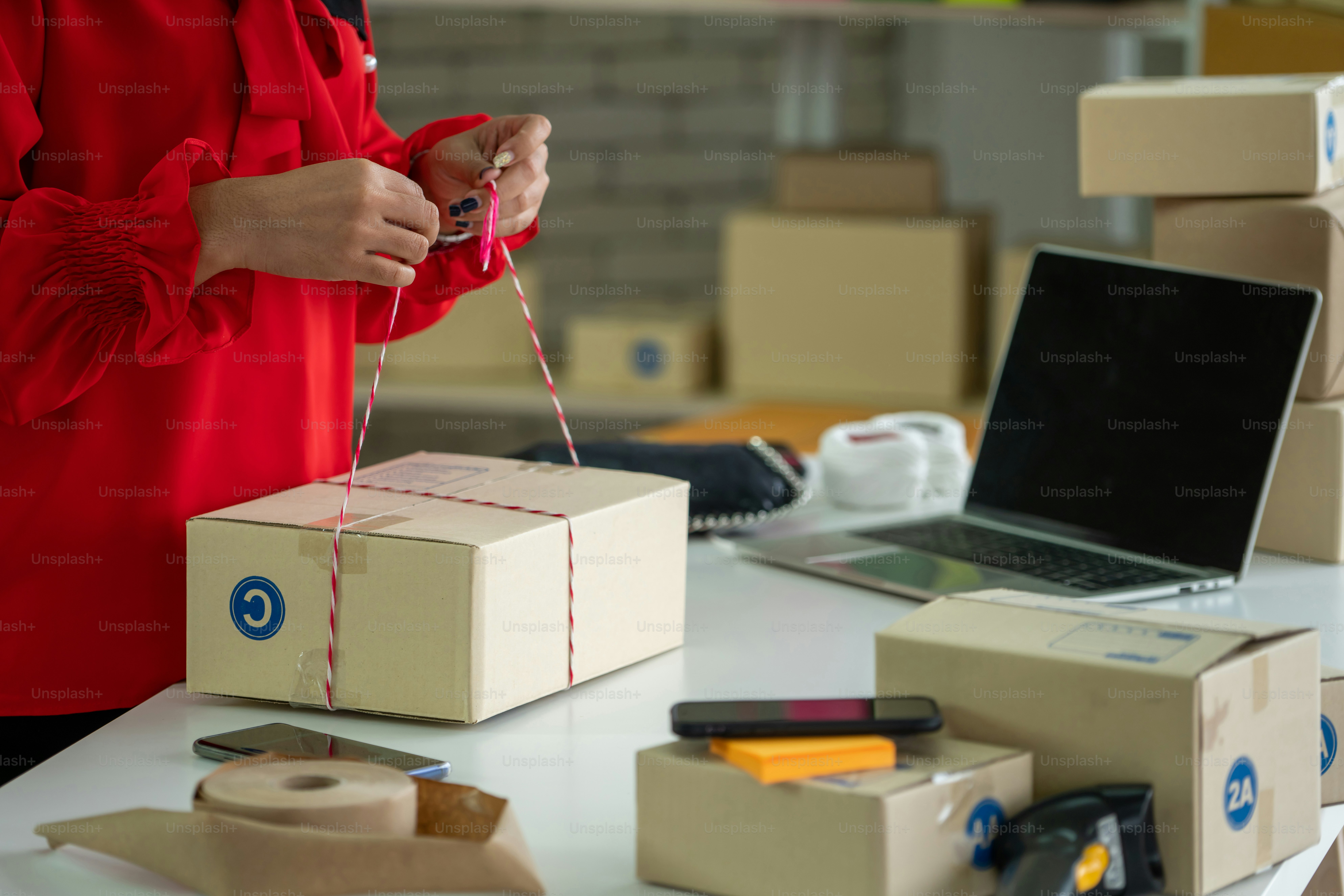 Online seller works at home office and packs shipping delivery box to ...