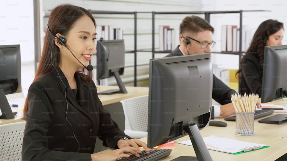 Pessoas de negócios usando fone de ouvido trabalhando no escritório para apoiar o cliente ou colega remoto. Call center, telemarketing, agente de suporte ao cliente prestam atendimento em chamada telefônica por videoconferência.