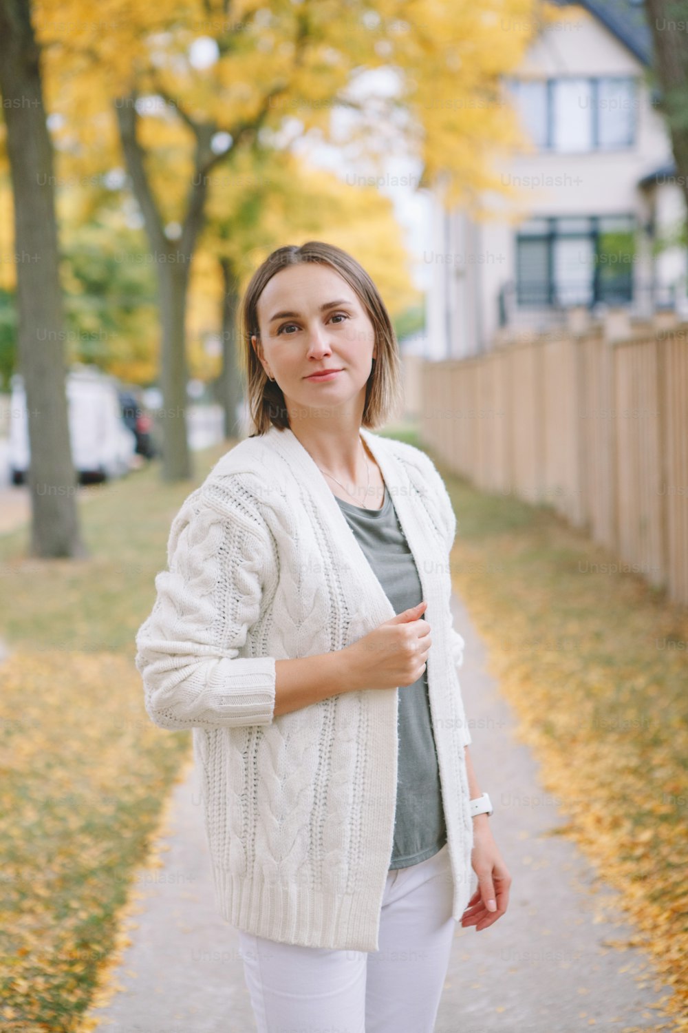 Beautiful middle age Caucasian woman with short hair walking in autumn fall street outdoor. Young woman with short haircut in casual clothes in park outside. Little memorable moments of life.