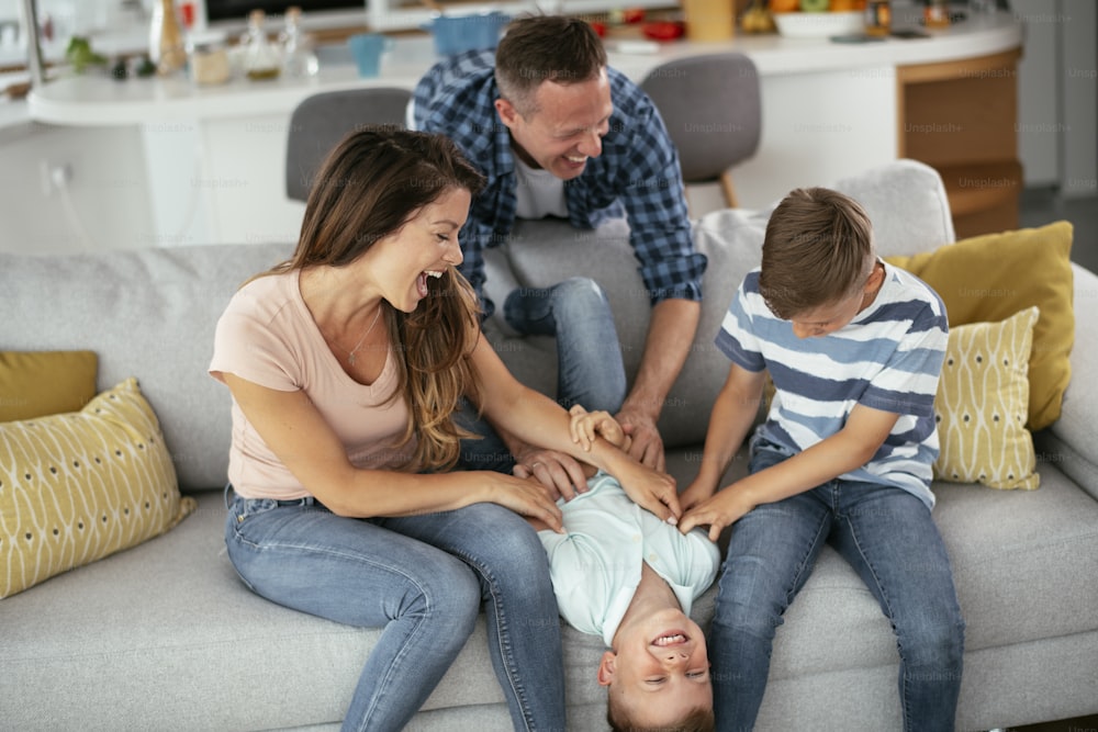 Young family enjoying at home. Happy parents with sons having fun.