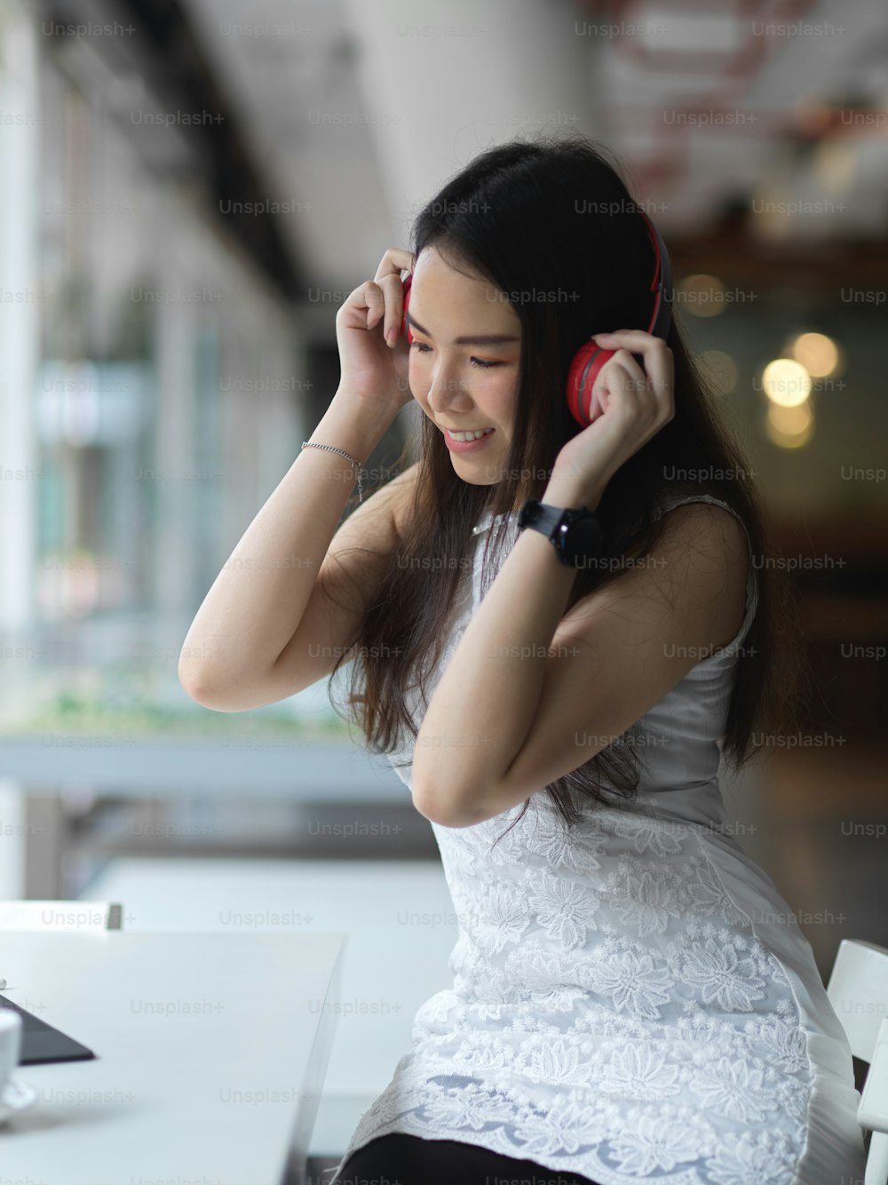 Portrait of female teenager listening music with headphone while relaxing in cafe