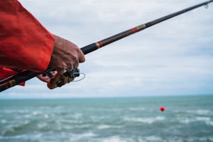 Close-up of a fisherman holding a fishing pole. Fishing and sport concept.
