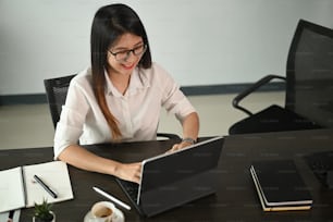 Junge schöne Geschäftsfrau arbeitet an ihrem Projekt mit Conputer Tablet im Büro.
