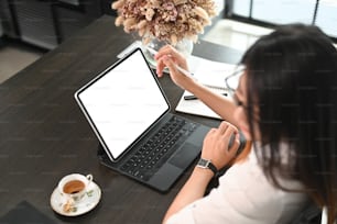 Young female working with empty screen digital tablet on black table at office.