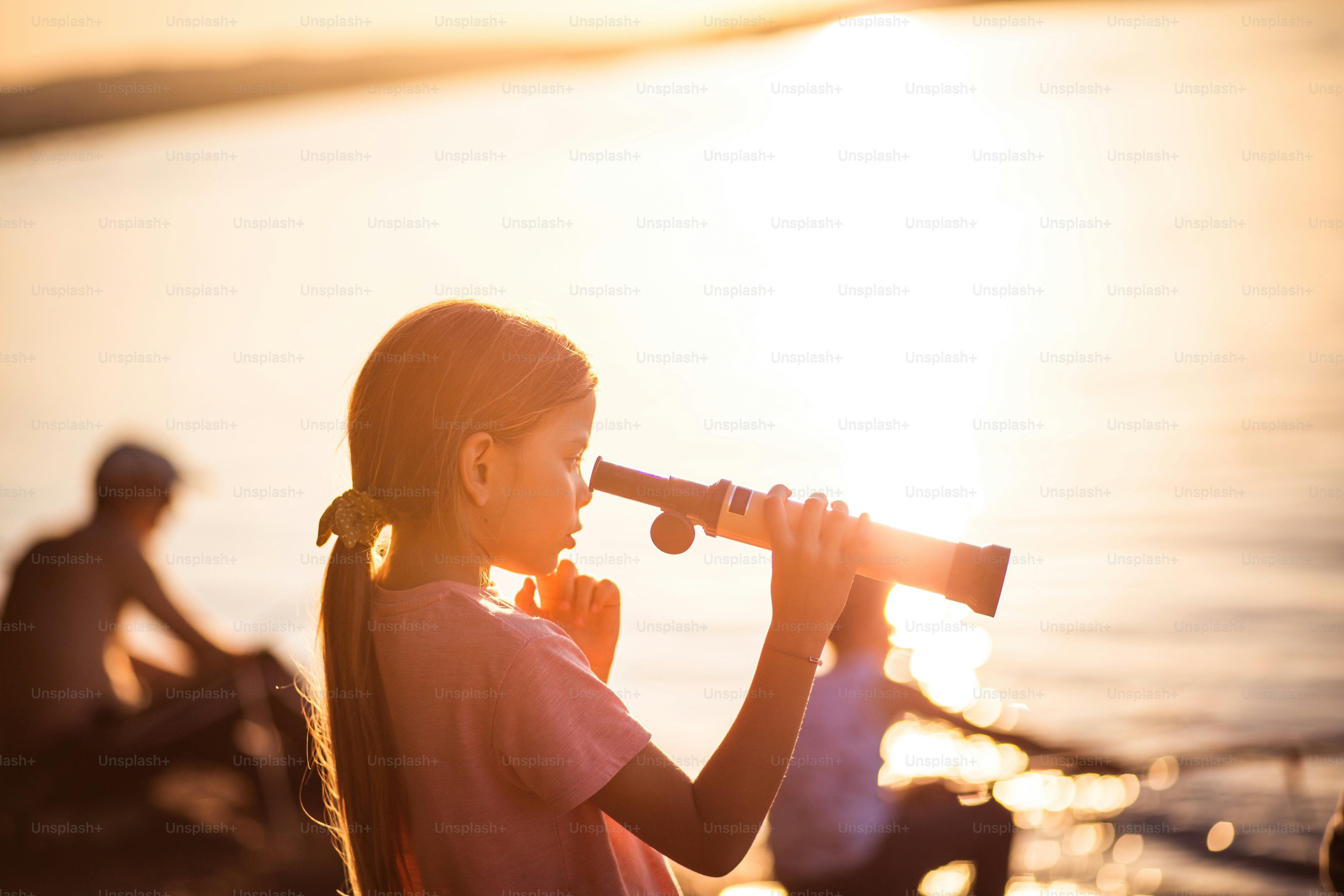 Telescope and fun.  Little girl looking through telescope outside.