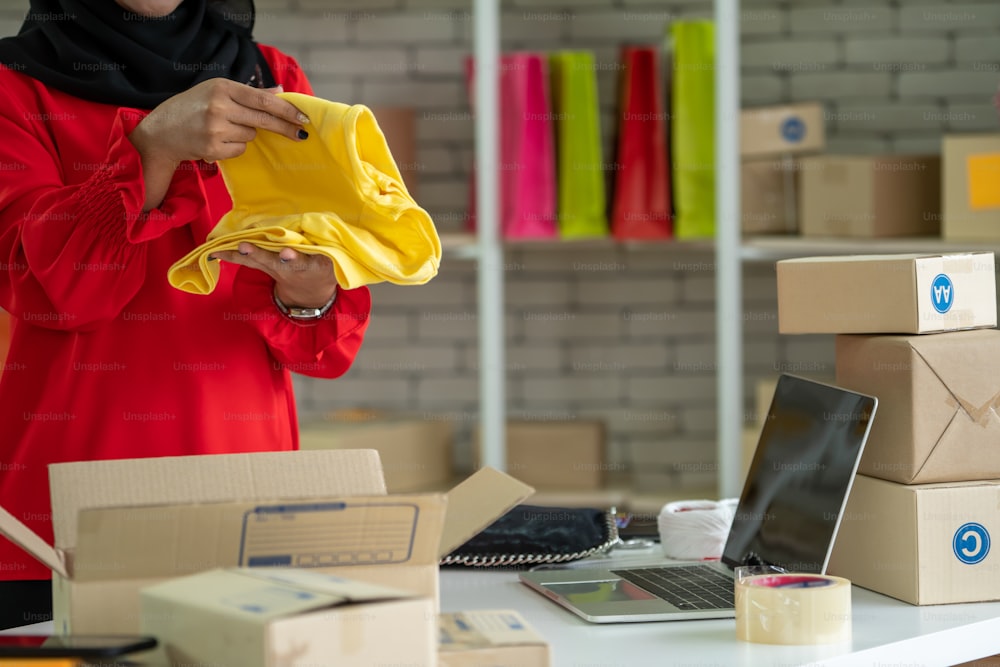 온라인 판매자는 홈 오피스에서 일하고 고객에게 배송 배달 상자를 포장합니다. 인터넷에서 전자 상거래 비즈니스를 하는 소기업 소유자 또는 기업가.