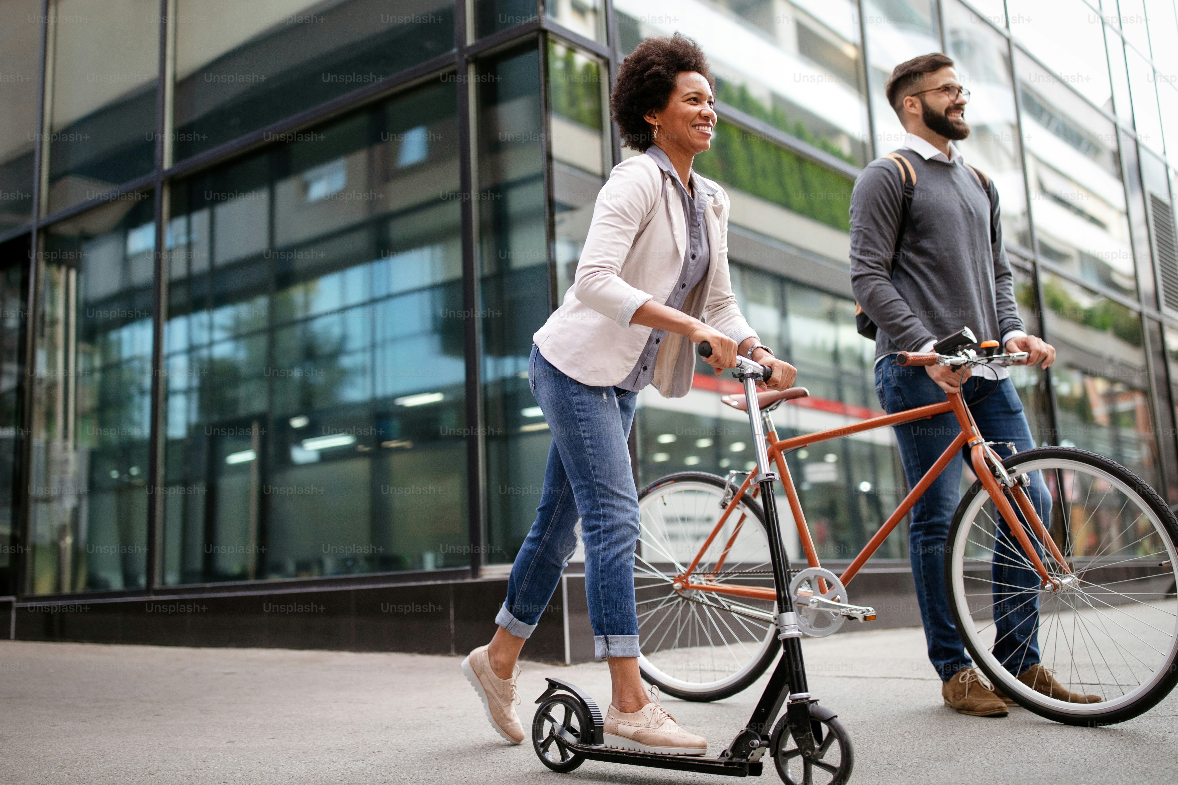 Happy interracial couple using electric scooter, bicycle in city. Green eco energy concept with zero emission