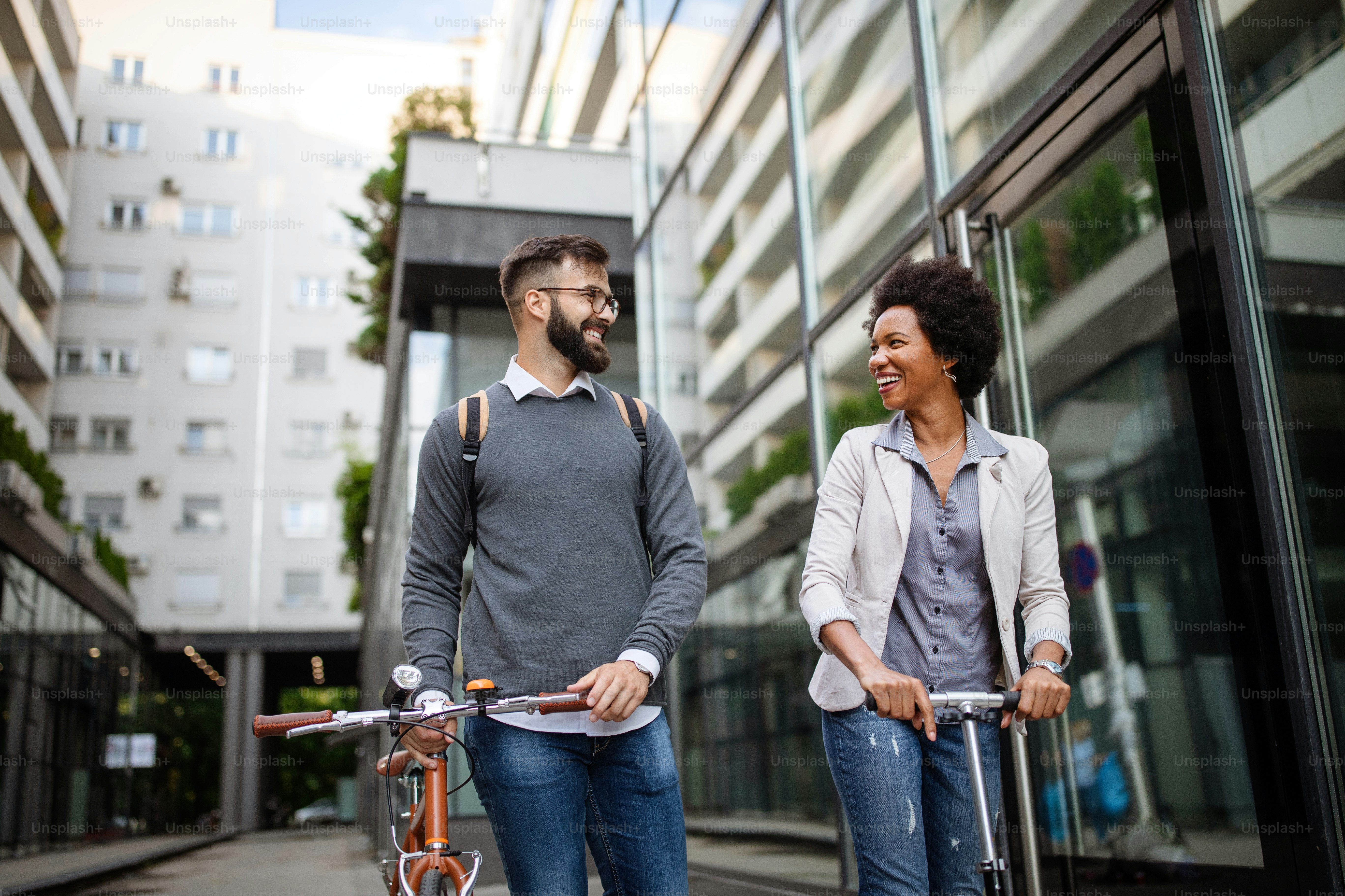 Happy interracial couple using electric scooter, bicycle in city. Green eco energy concept with zero emission