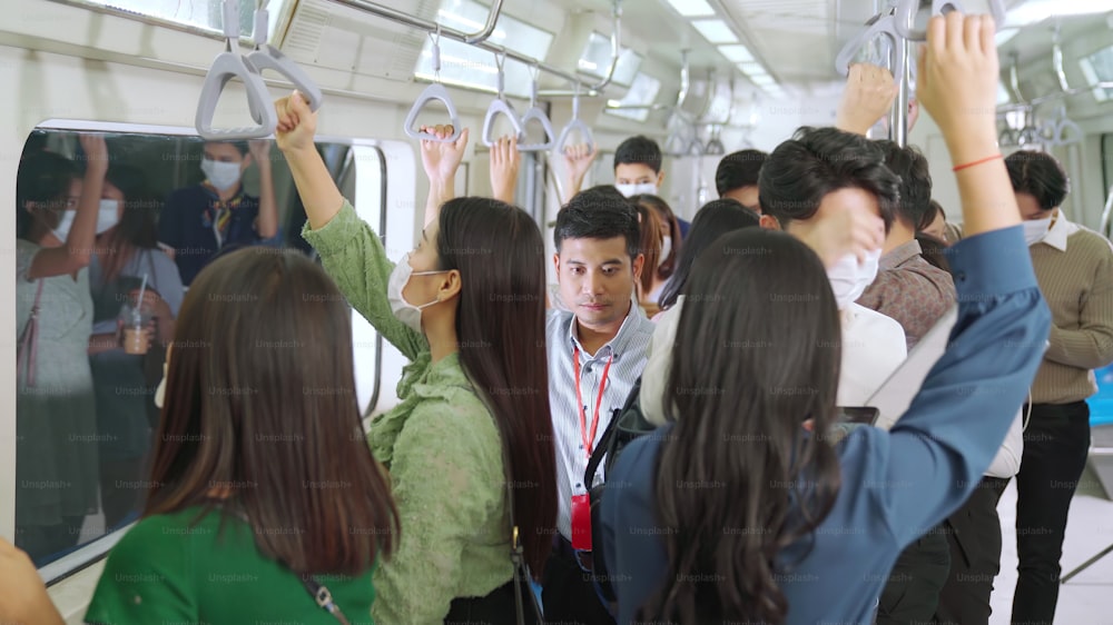 Multidão de pessoas usando máscara facial em uma viagem de trem público lotada do metrô. Doença por coronavírus ou surto de pandemia de COVID 19 e problema de estilo de vida urbano no conceito de hora do rush.