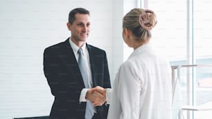 Business people handshake in corporate office showing professional agreement on a financial deal contract.