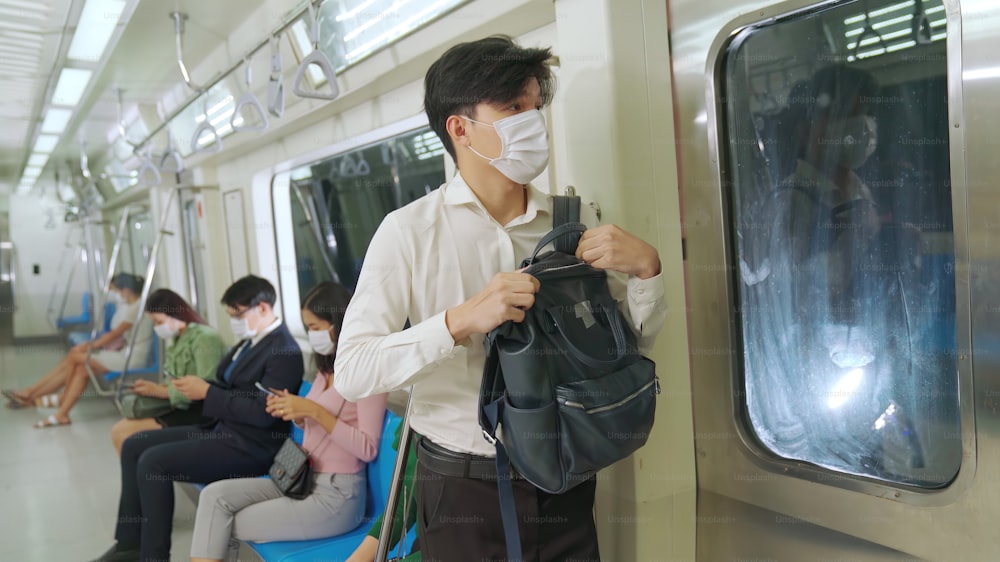 混雑した公共の地下鉄の列車旅行でフェイスマスクを着用している人々の群衆。コロナウイルス病またはCOVID19パンデミックの発生とラッシュアワーのコンセプトにおける都市ライフスタイルの問題。