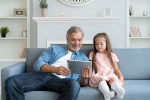 Daddy with little girl playing with tablet