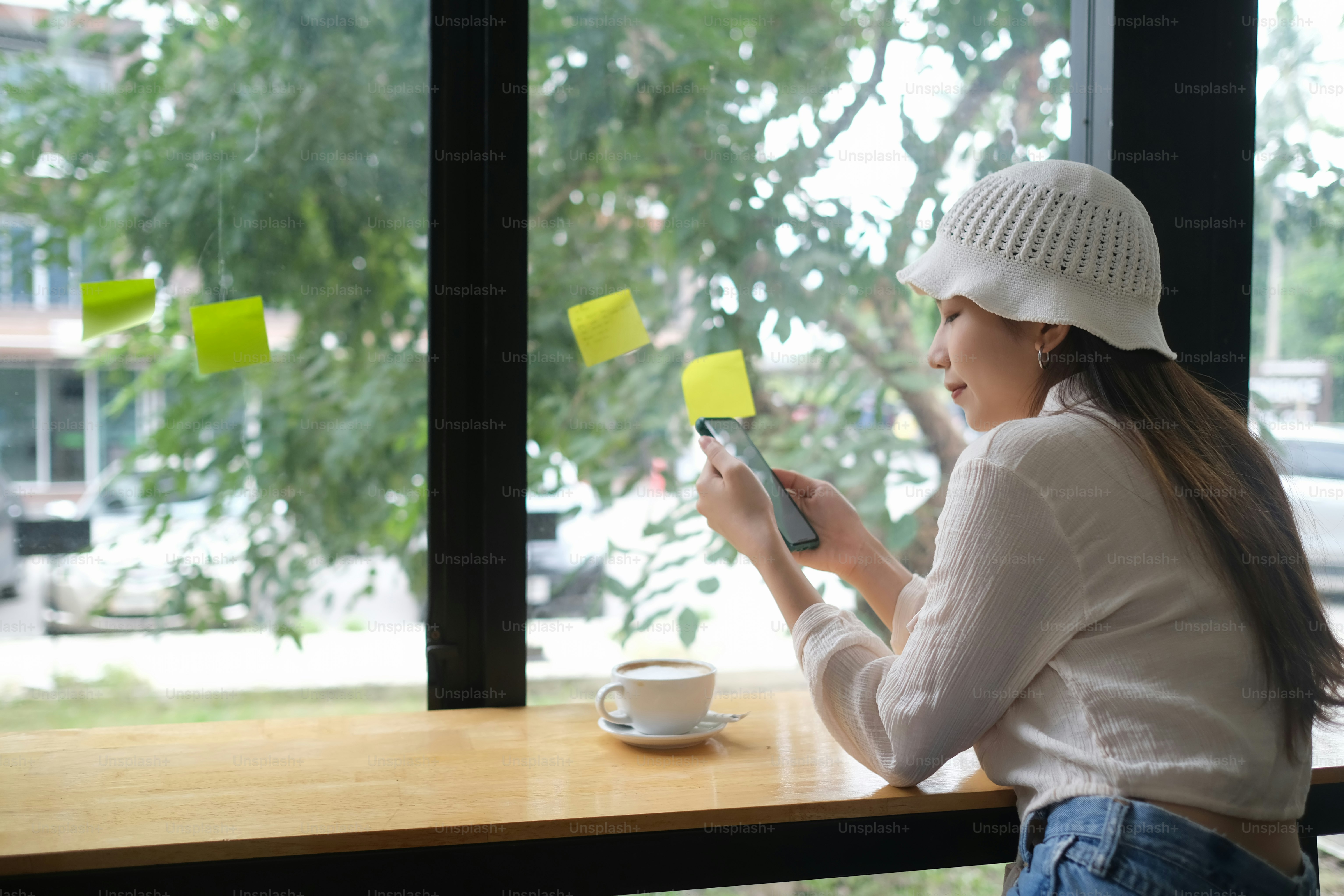 A young woman take a break with smartphone while online working in office.