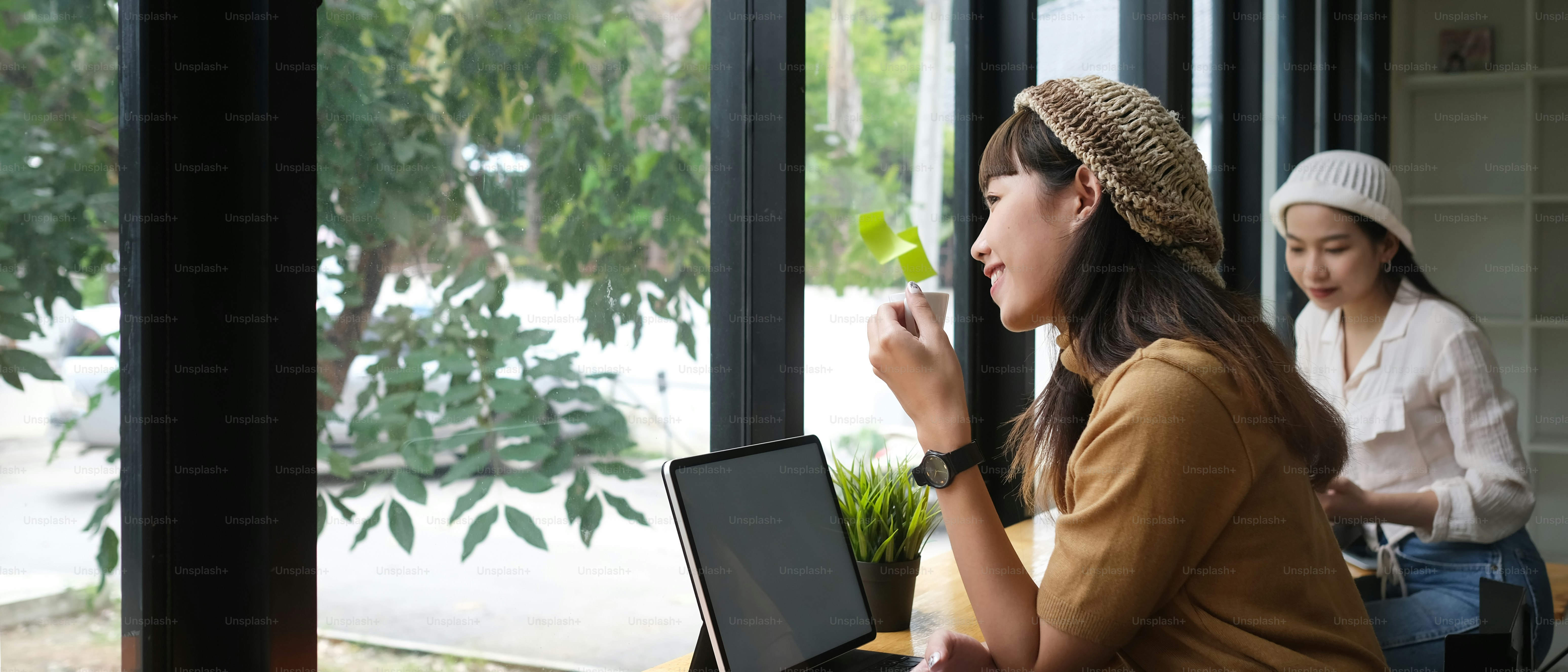 Side view of woman take a break with coffee cup while online working in meeting room.