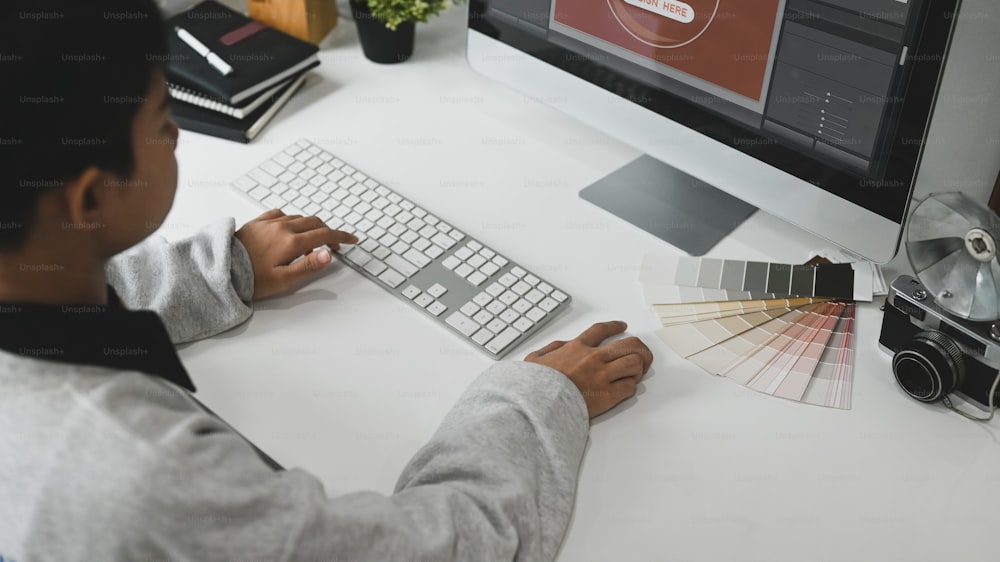 A young graphic designer woman using colour swatch samples for work  at her work space.