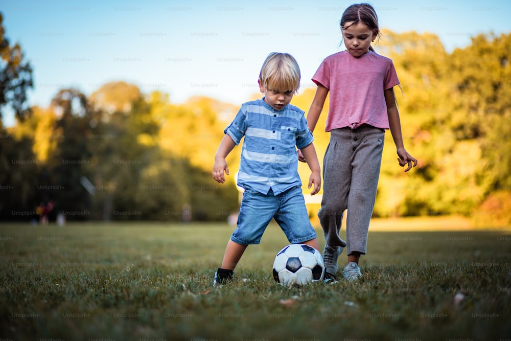 Competition.  Sister and brother playing football.