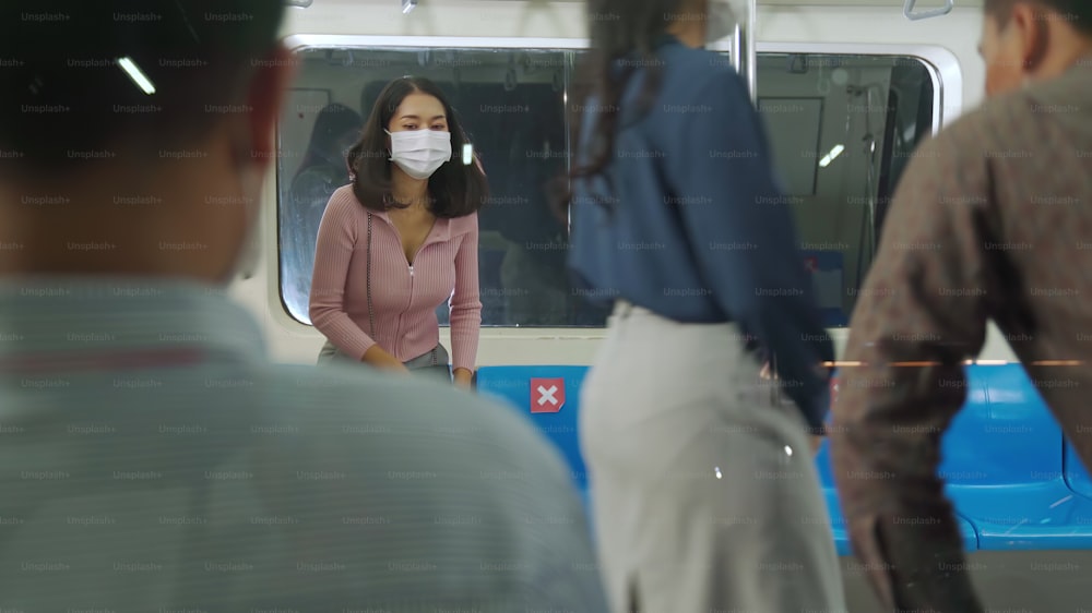 混雑した公共の地下鉄の列車旅行でフェイスマスクを着用している人々の群衆。コロナウイルス病またはCOVID19パンデミックの発生とラッシュアワーのコンセプトにおける都市ライフスタイルの問題。