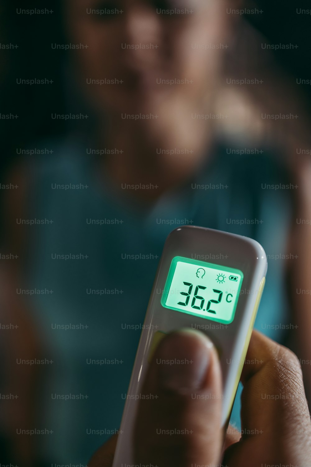 Young male fitness gym worker and instructor measuring body temperature of young sporty woman with infrared thermometer. Coronavirus world pandemic and sport theme.