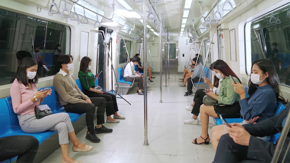 Folla di persone che indossano la maschera facciale su un affollato viaggio in treno della metropolitana pubblica. Malattia da coronavirus o epidemia di pandemia COVID 19 e problema di stile di vita urbano nel concetto di ora di punta.