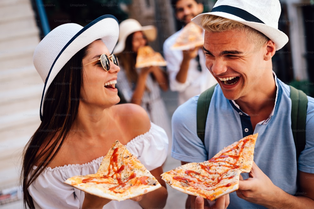 Friends having fun outdoors,eating pizza on summer vacation