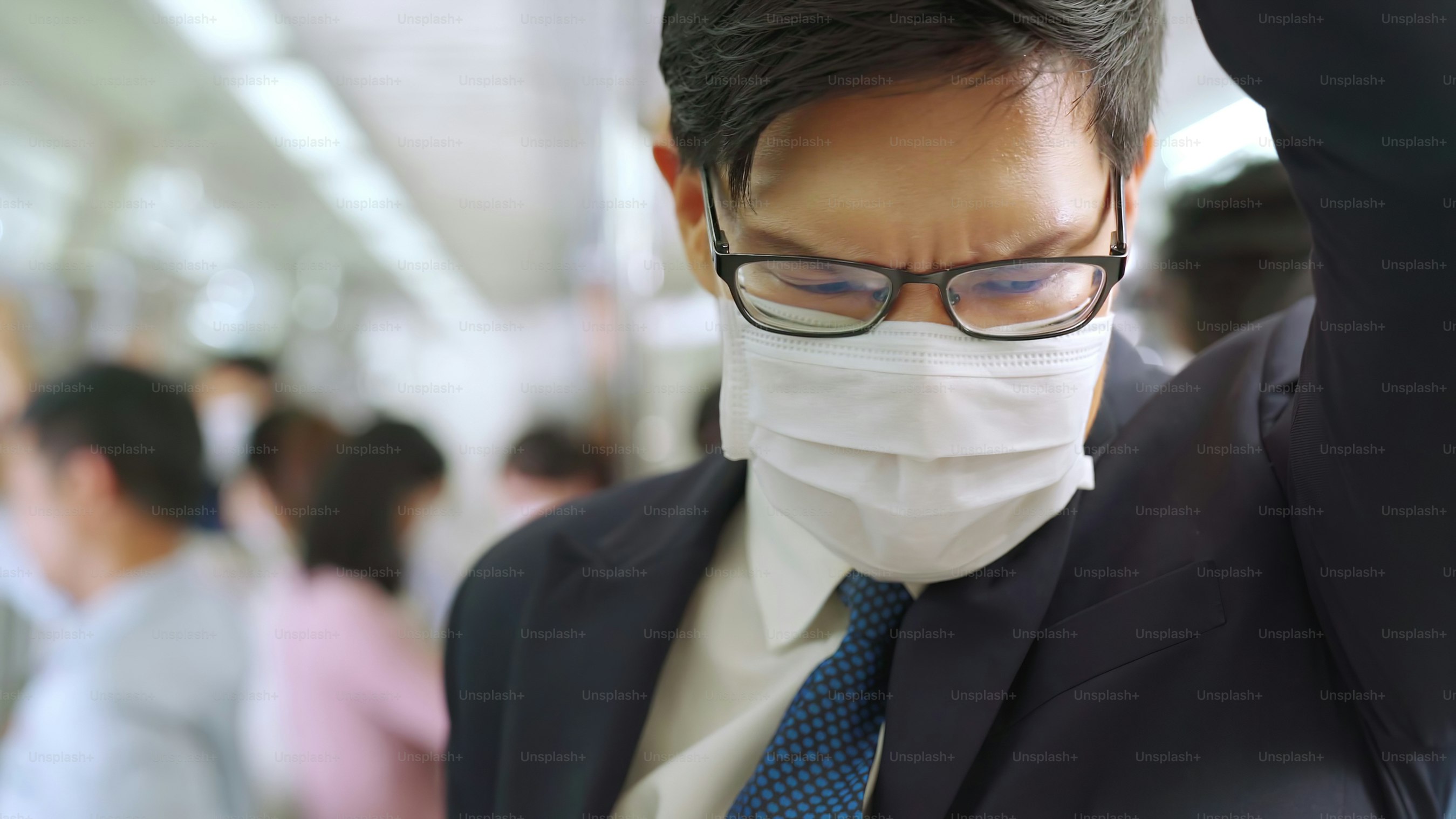 Young man wearing face mask travels on crowded subway train . Coronavirus disease or COVID 19 pandemic outbreak and urban lifestyle problem in rush hour concept .