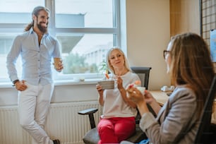 A lunch time in the office. Business people having their lunch from lunch boxes in the modern workspace.