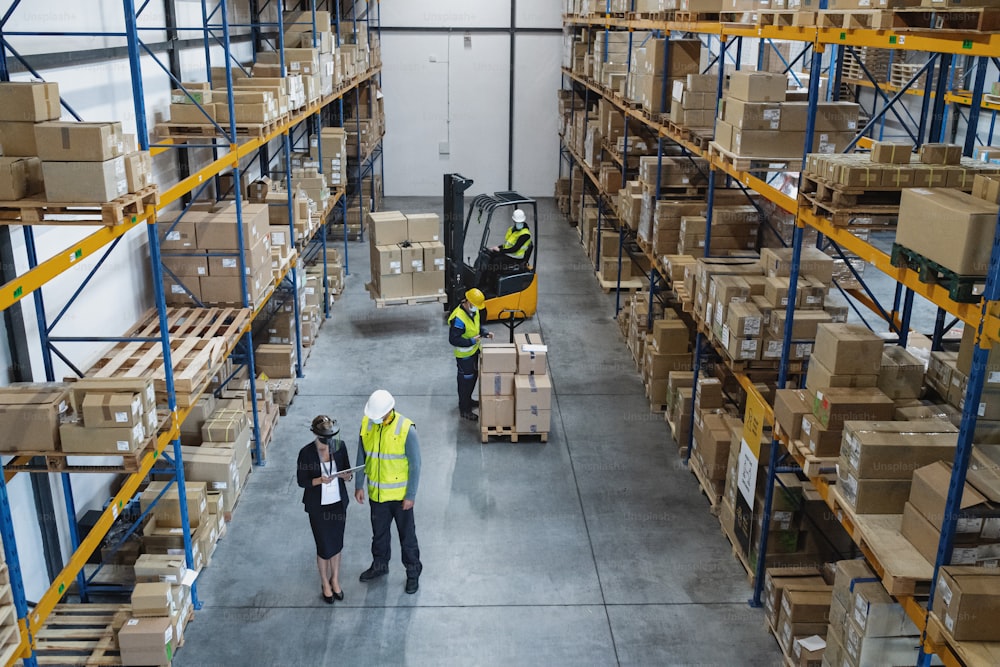 Top view of group of workers with manager working indoors in warehouse, coronavirus concept.