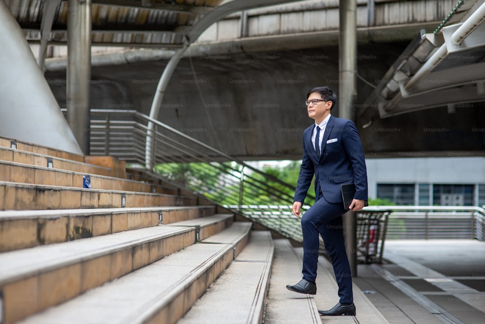 Asian businessman walking up the stairs in the city.