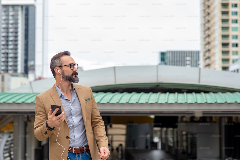 Caucasian beard man using smartphone with earphone for video call or Vlogging