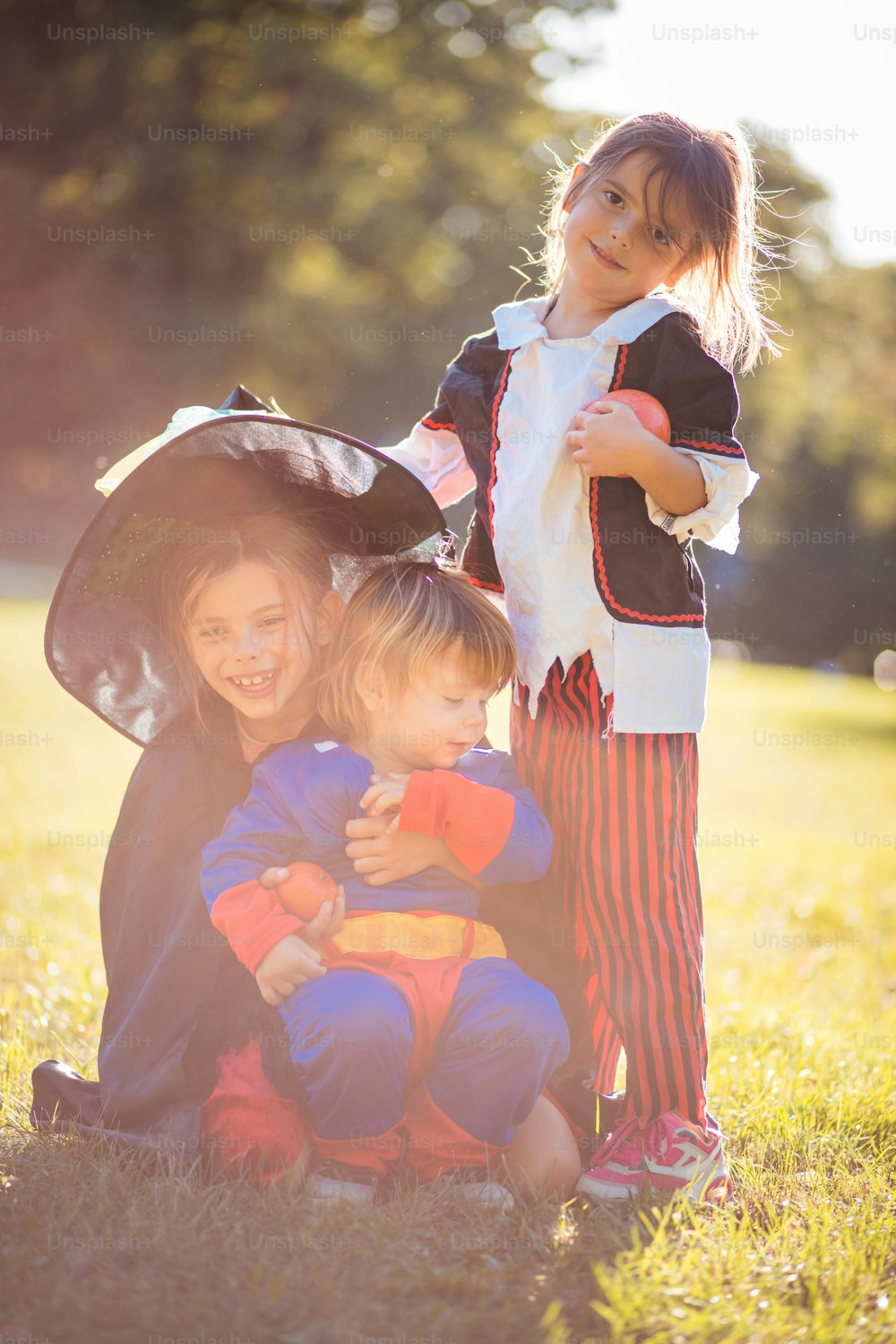 Crianças vestindo ternos de Halloween e brincando no parque.