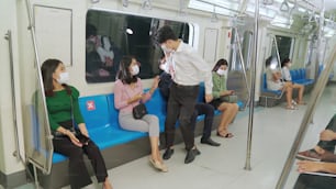 여자는 사회적 거리두기를 위해 기차에��서 남자가 그녀 옆에 앉는 것을 막습니다. 코로나바이러스 질병 또는 COVID 19 팬데믹 발생 및 러시 아워 개념의 도시 생활 방식 문제.