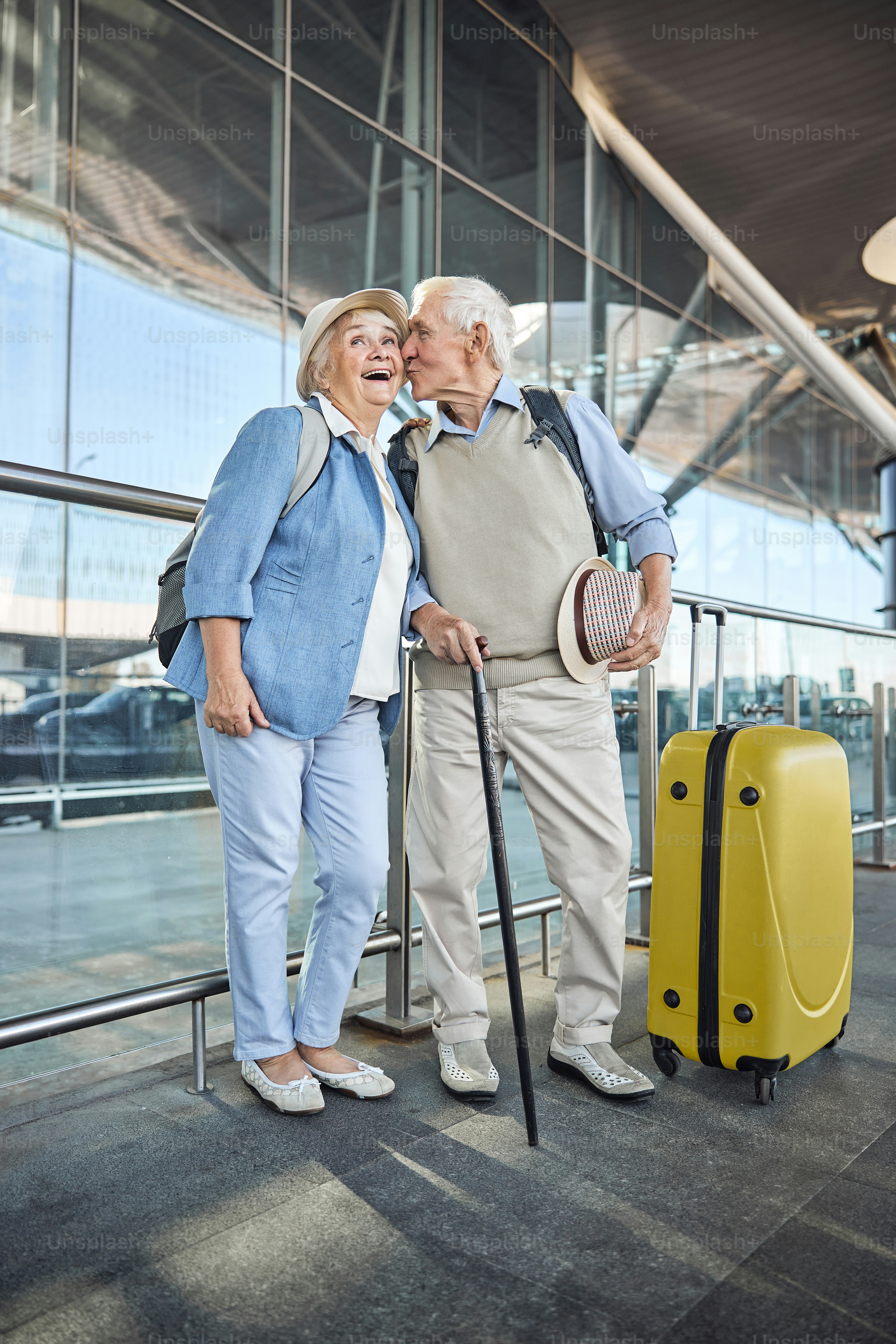 Retrato de cuerpo entero de un hombre con un bastón dando un beso a una anciana