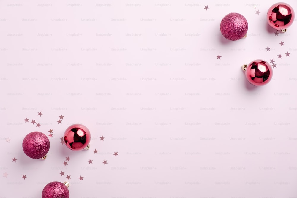 Sfondo natalizio rosa con decorazione di palline e coriandoli su rosa. Posa piatta, vista dall'alto. Modello di cartolina di Natale, mockup di banner per blog di bellezza.