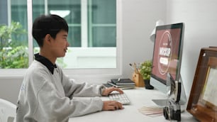 Side view of female graphic designer  working on her project while using blank screen computer t in modern office.