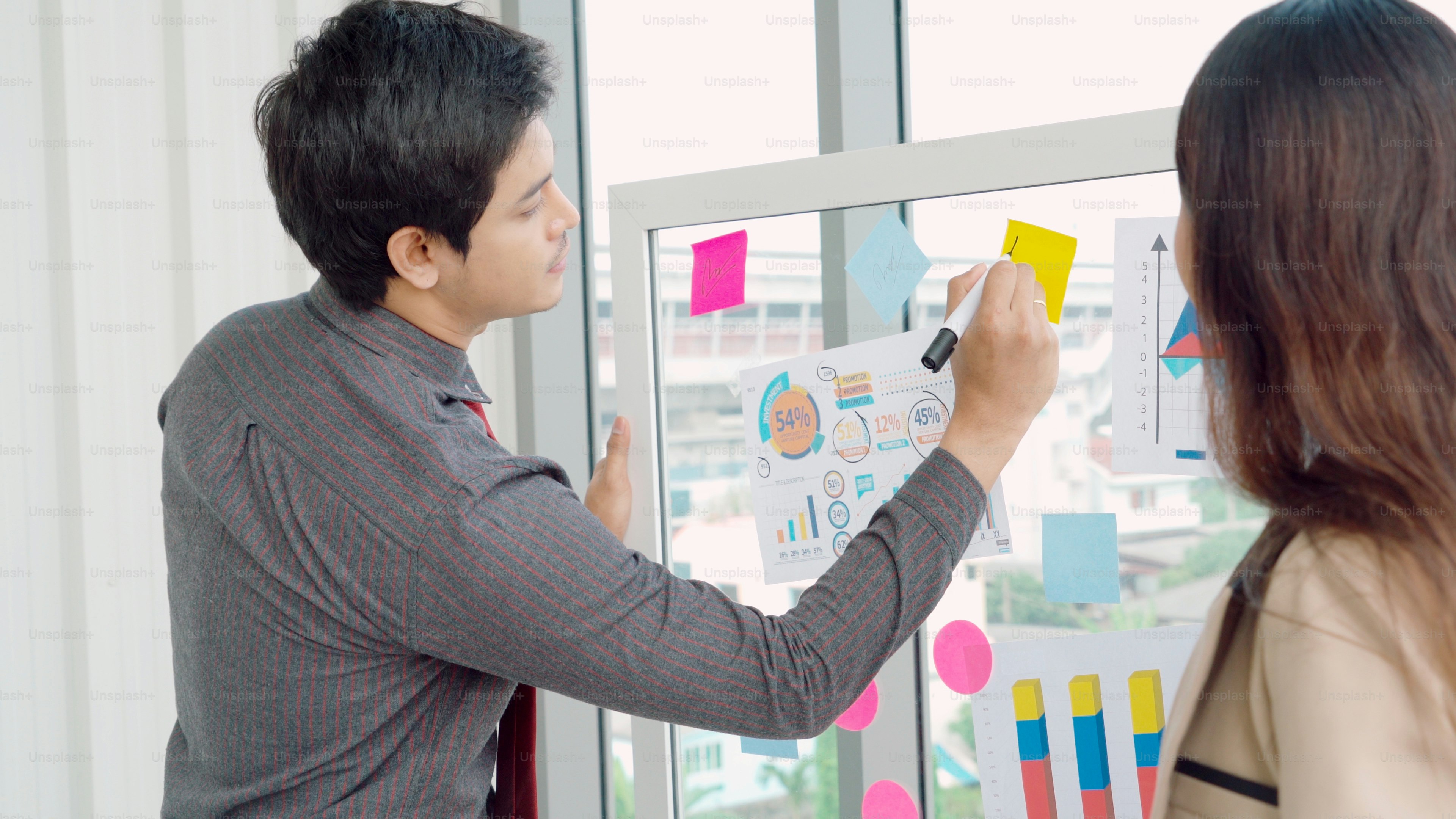Business colleagues discussing charts in office - Photo on Unsplash+
