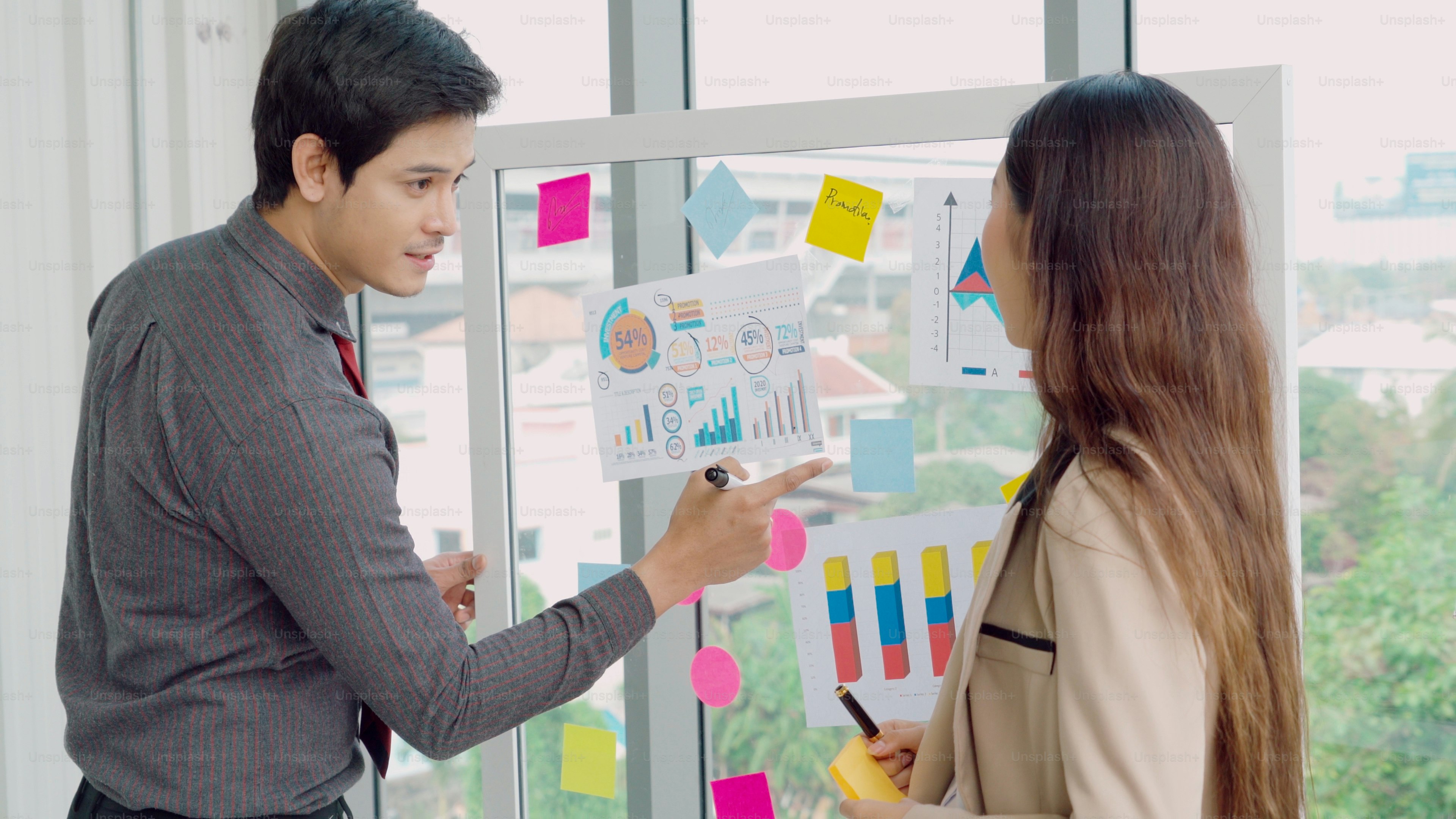 Business colleagues discussing charts in office - Photo on Unsplash+