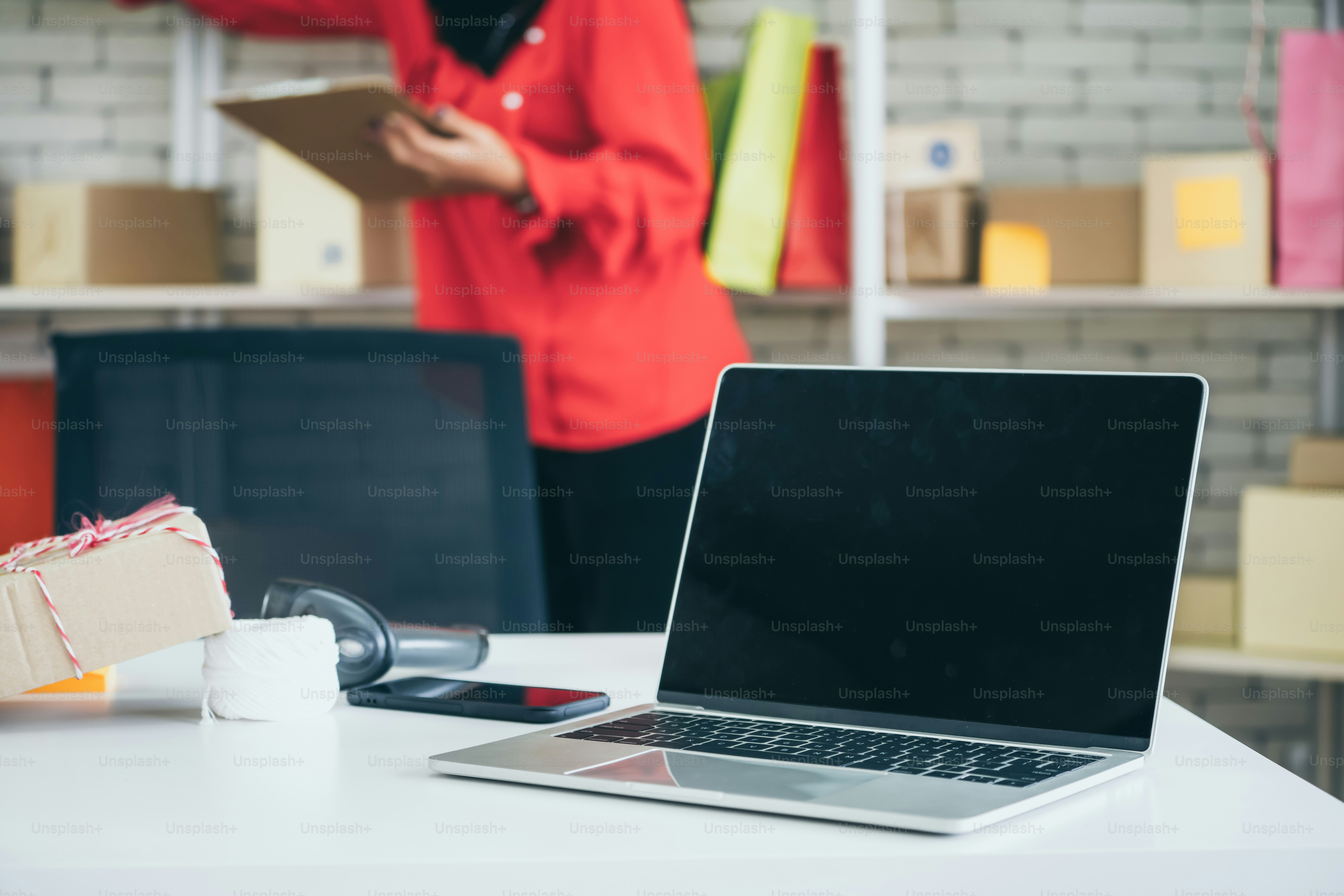 Laptop computer with empty screen on shipping box background. Concept of online retail store, delivery order and customer service.