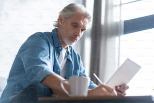 Handsome businessman working on tablet from home