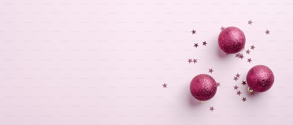 Christmas banner mockup. Christmas balls decoration and confetti on pink background with copy space. Xmas sale header.