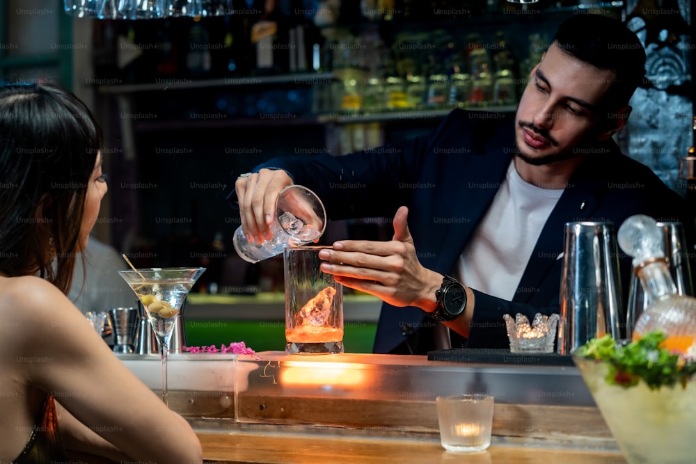 Male bartender pouring making alcoholic drink to female customer