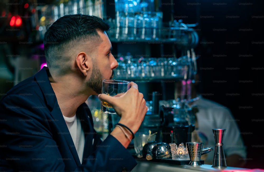 Portrait of Caucasian man sitting at bar counter enjoy drinking alcoholic drink