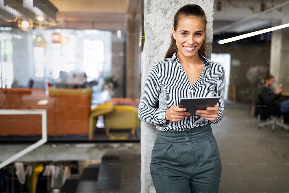 Portrait of happy confident business woman with digital tablet in office