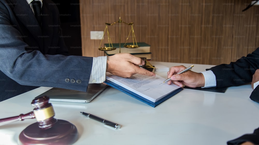 El abogado da a sus clientes un contrato firmado en el documento. Asesoramiento en relación con los distintos contratos