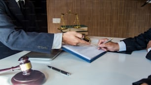L'avvocato dà ai suoi clienti un contratto firmato nel documento. Consulenza in merito ai vari contratti