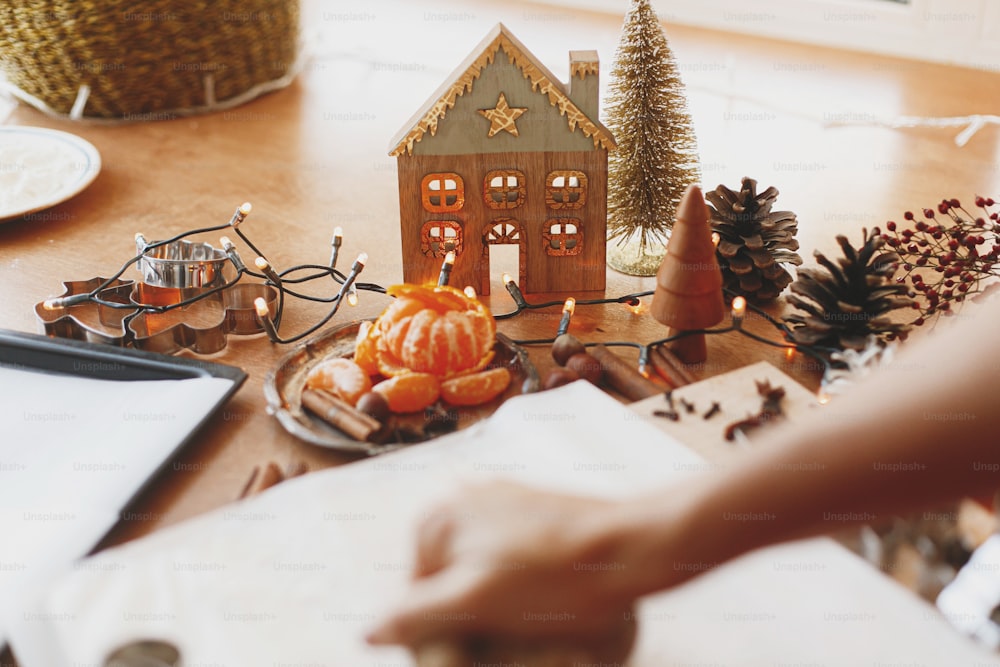 Decorazioni natalizie festive su tavola rustica con pasta di pan di zenzero crudo, taglierine metalliche, spezie, arance, farina. Vacanze di Natale Avvento