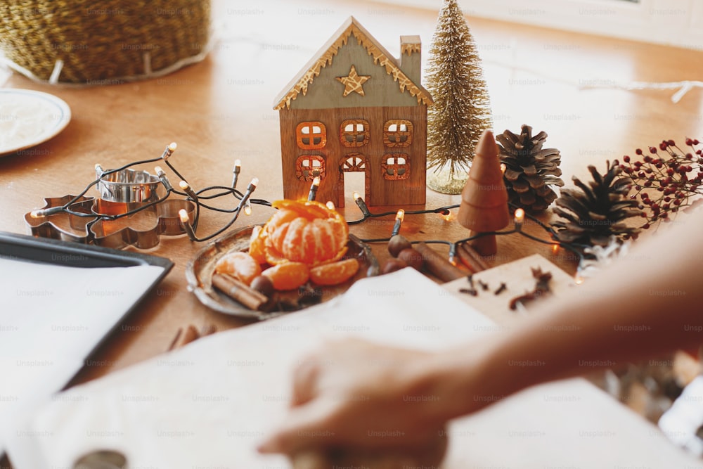 Festive christmas decorations on rustic table with raw gingerbread dough, metal cutters, spices, oranges, flour. Christmas holiday advent