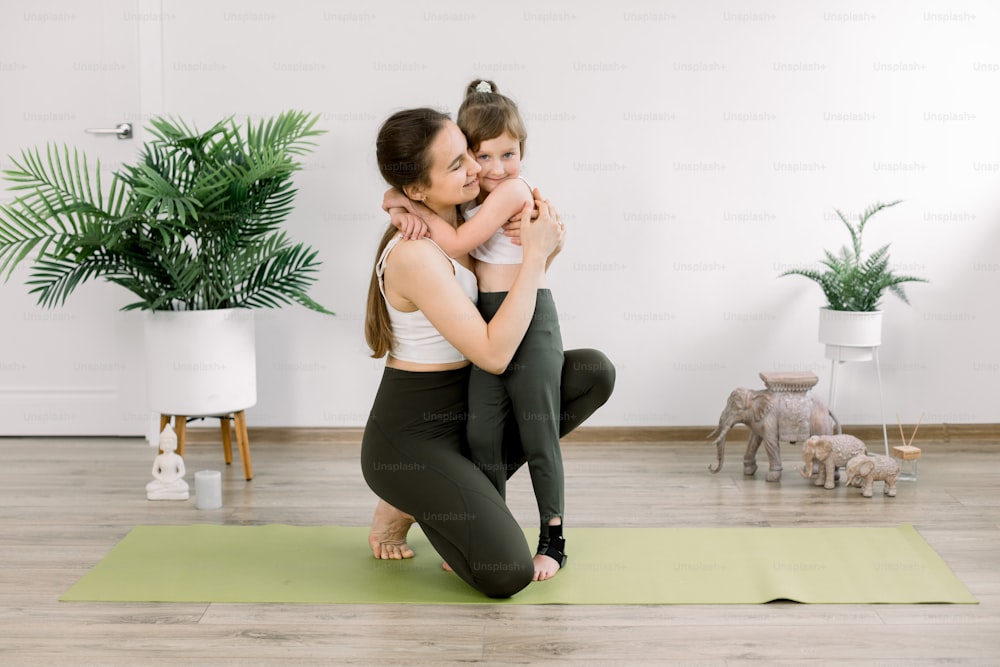 Mother and daughter spending time together doing yoga exercise home. Pretty  woman and little child girl, hugging each other after joint fitness  training. Family sport concept. photo – Flooring Image on Unsplash
