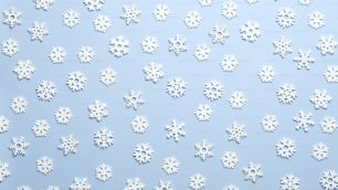 White snowflakes Christmas decorations on blue background. Pattern of snowflakes, Christmas card.