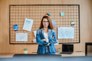Attractive business woman in glasses standing in the modern office.